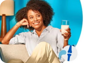 Mulher sorrindo com uma caneca de leite