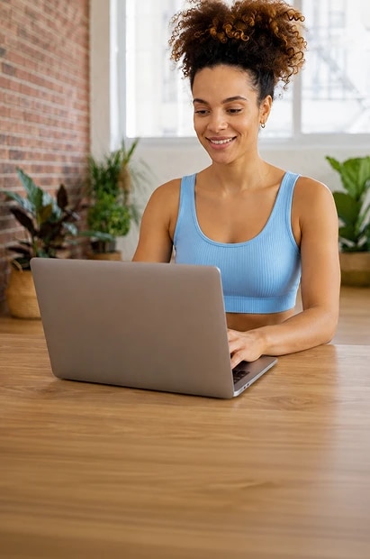 Pessoa sentada em frente ao notebook em um cômodo iluminado